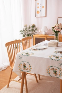 Detail of linen tablecloth featuring yellow tulip rings and green ribbon patterns