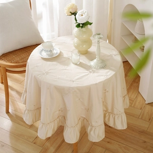 Elegant beige cotton round tablecloth featuring floral embroidery and ruffled edges for home