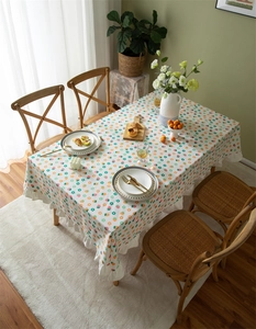 Detail of floral strawberry print tablecloth with decorative ruffled edges on a table