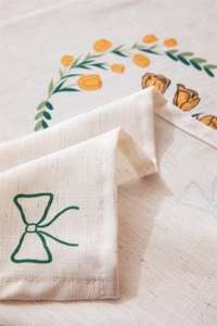 Close-up of linen fabric showing tulip prints and delicate embroidery details