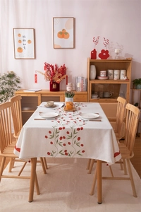 Close-up of red tulip print on beige cotton linen tablecloth for festive dining decor