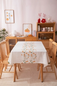 Close-up of linen tablecloth featuring digital tulip prints and soft orange flower motifs