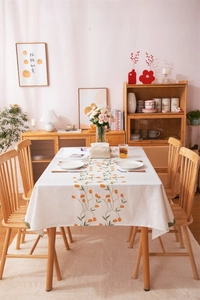 Detailed close-up of tulip floral print on cream-white linen tablecloth fabric