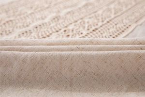 Macro view of beige linen fabric texture with hollow lace crochet edge detail