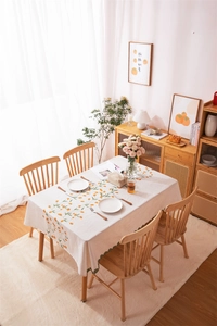 Detail of linen-textured tablecloth with orange persimmon prints and floral patterns