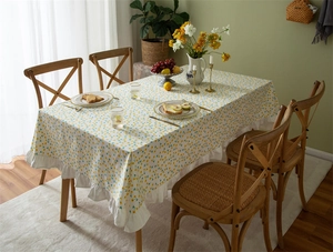 Detail of floral print cotton tablecloth featuring elegant white ruffled edges for home decor