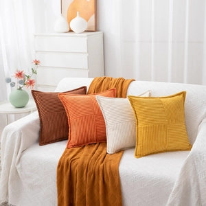 Close-up of corduroy striped patchwork pillow covers in warm orange and brown tones