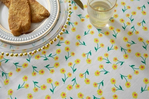 Detail of floral cotton tablecloth with ruffles and fresh green leaf pattern for dining