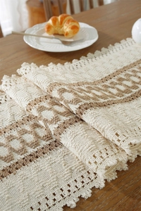 Close-up of woven cotton linen table runner with heart pattern and tassel details