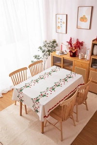 Detailed close-up of a strawberry vine pattern on a white tablecloth with red scalloped edges