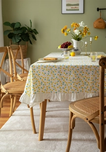 Close-up of cotton floral tablecloth with yellow flower print and ruffled hem detail