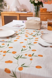 Detail of linen tablecloth with orange tulip print and fresh pastoral home decoration