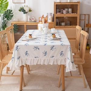 Close-up of blue floral cotton tablecloth with elegant ruffled edges and floral pattern