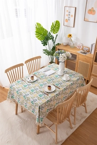 Close-up of green leaf pattern on cotton linen tablecloth with elegant beige fringe trim