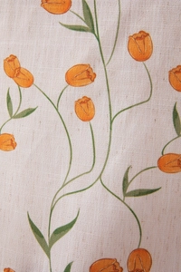 Close-up of linen-texture tablecloth featuring digital orange tulip floral prints