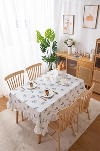 Detail of blue floral cotton tablecloth featuring ruffled edges and waterproof texture