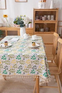 Detail of leaf pattern printing and beige tassels on rectangle cotton linen tablecloth