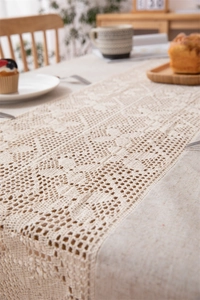 Detailed macro view of beige crochet hollow pattern and linen stitching table runner fabric