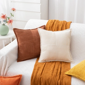 Detail of corduroy pillow cover with striped patchwork texture on a white sofa