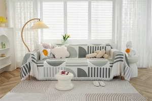 Detail of waffle knit fabric texture and fringe edges on a geometric pattern sofa cover
