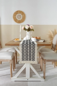 Detail of cotton linen woven table runner with black and white geometric rhombus and tassels