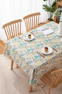 Detailed top view of a leafy pattern cotton linen tablecloth with beige fringe tassels