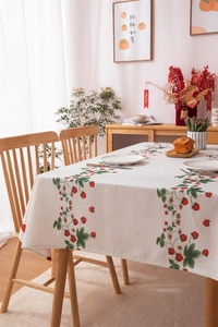 Detail of red strawberry print on linen-textured tablecloth for festive home decor