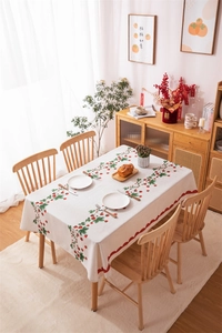 Detail of red strawberry print on white tablecloth with decorative wavy scalloped edges