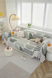 Detail of Nordic waffle texture sofa cover with geometric prints and fringe tassels