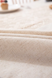 Close-up of beige cotton linen tablecloth texture with natural woven fiber details