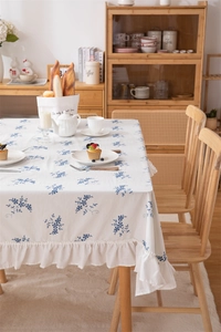 Close-up of French blue floral embroidery and ruffle edge on cotton tablecloth