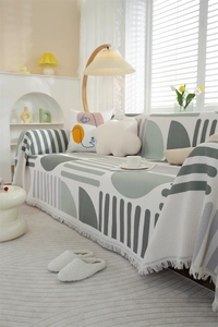 Close-up detail of waffle weave sofa cover with geometric pattern and fringe edges
