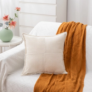Detailed texture of corduroy patchwork pattern on a cream square cushion cover