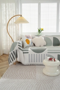 Detail of waffle weave throw blanket with green geometric prints and fine fringe tassels