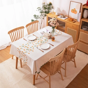 Modern linen tablecloth with orange fruit prints and green scalloped edges for home dining