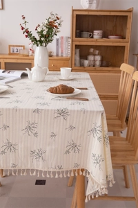 Detailed view of floral cotton tablecloth with elegant white fringe tassel edge and texture
