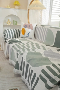 Detail of waffle weave fabric texture with green geometric pattern and fringe tassels