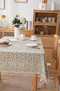 Close-up of fresh orange leaf print on cotton tablecloth with tassel fringe detail
