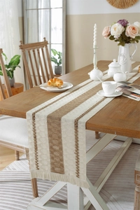 Close-up of woven linen table runner with striped pattern and decorative fringe details