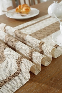 Detail of woven cotton linen table runner featuring beige stripes and rustic textures