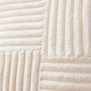 Detailed macro view of cream corduroy cushion cover with textured stripe pattern