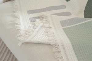 Macro view of waffle weave fabric texture with tassels and geometric print pattern