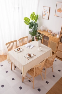 Detail of cream cotton tablecloth with yellow floral patterns and fringe edges