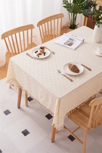Floral cotton tablecloth detail with yellow daisies and elegant cream tassels fringe
