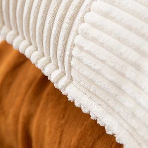Macro detail of striped corduroy cushion cover in cream and caramel soft textured fabric