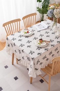 Close-up of black floral embroidery and elegant ruffle edge detail on cotton tablecloth