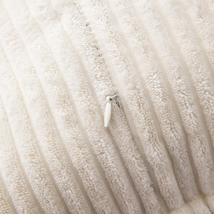 Close-up of cream corduroy pillow cover showing texture and invisible zipper detail