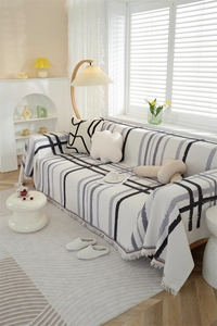 Close-up of Nordic waffle texture throw blanket with black geometric grid and tassel edge