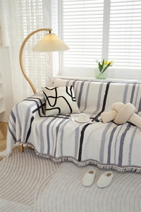 Detail of waffle print sofa cover with hand-drawn stripes and frayed tassel edges