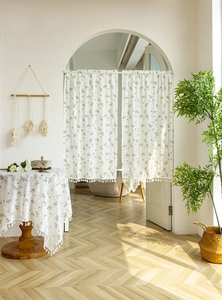 Close-up of cotton door curtain with green floral print and white tassel fringe detail